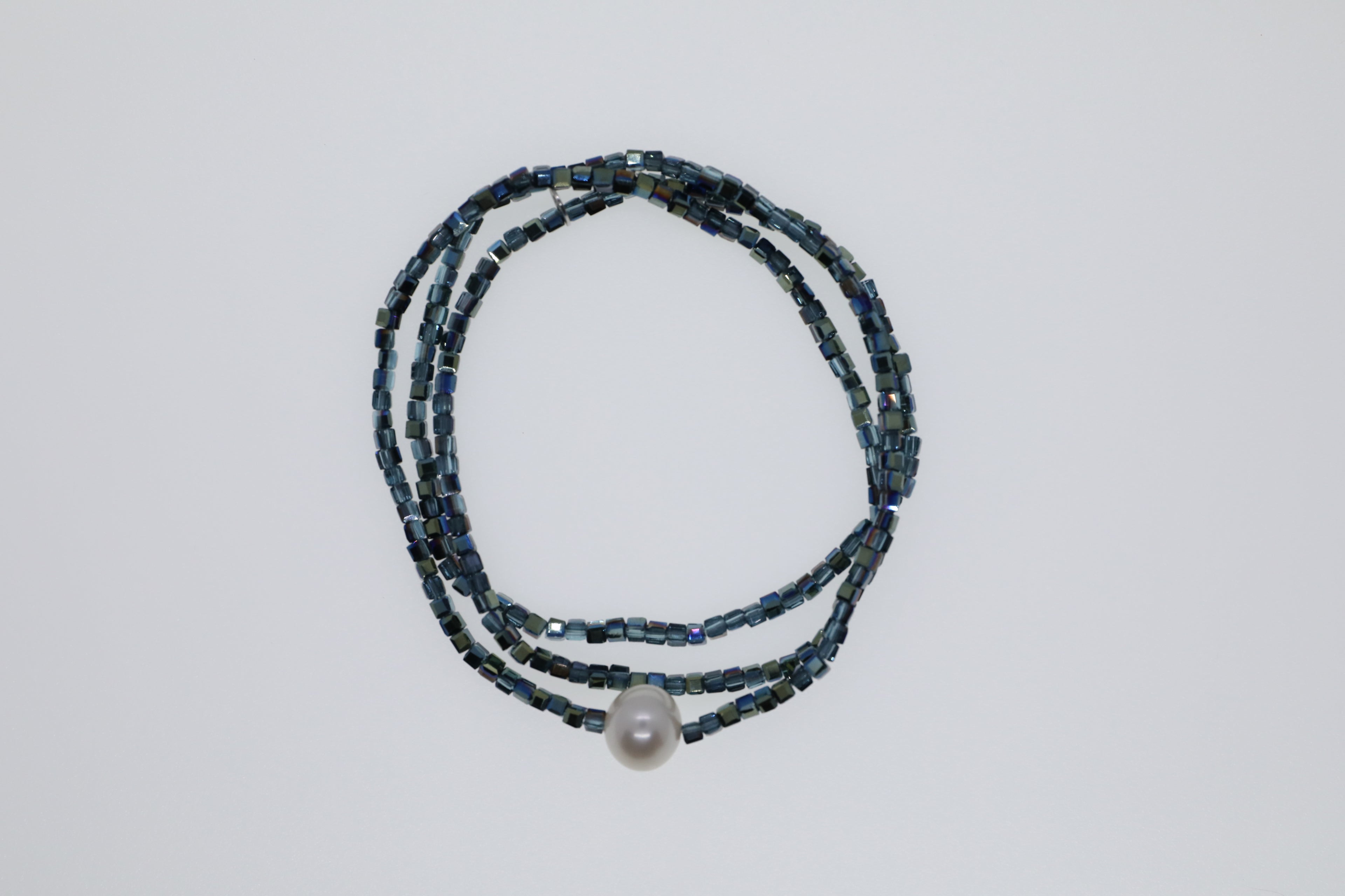 Petrolfarbene Glasperlen mit weißer Süßwasserperle