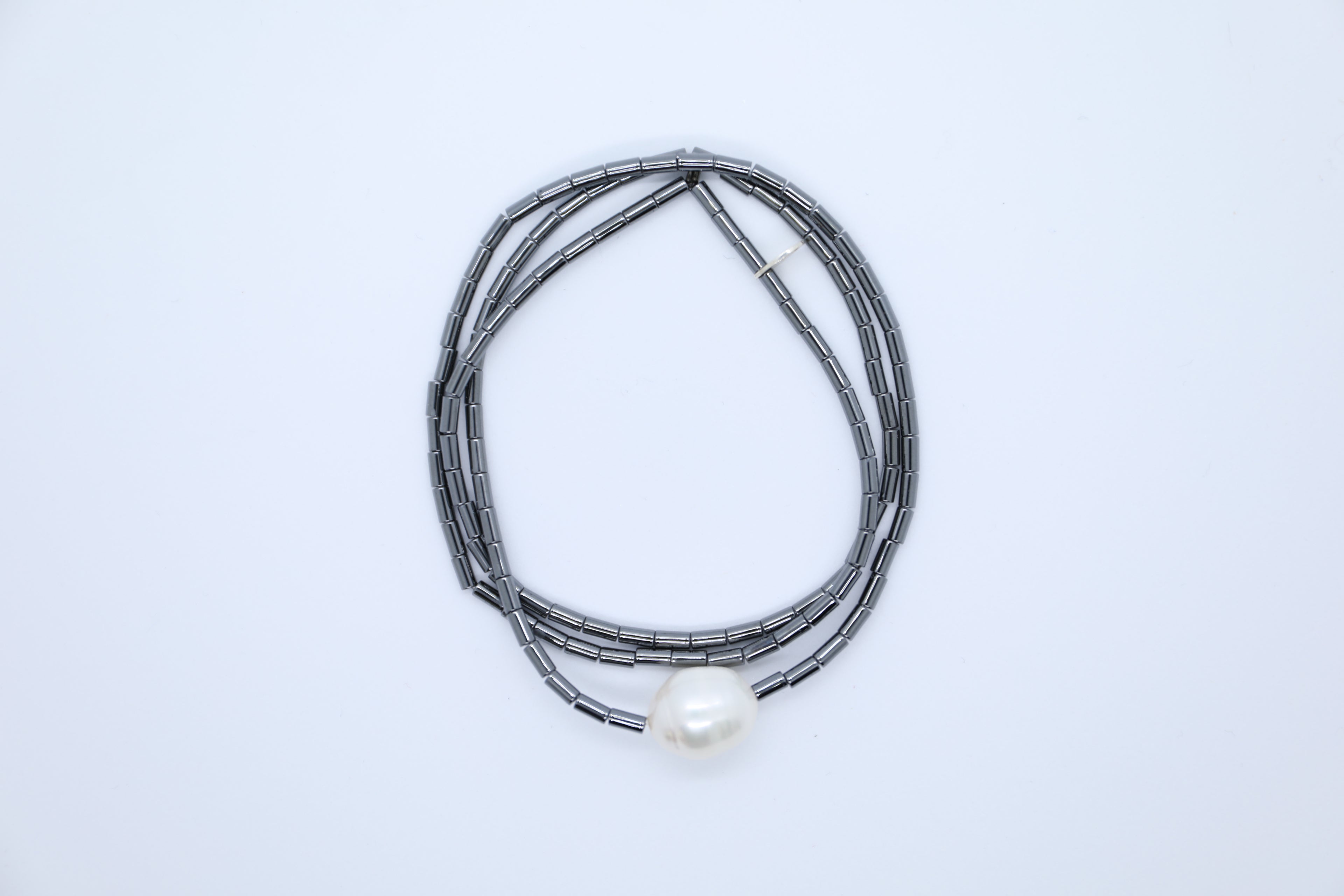 Weiße Süßwasserperle zusammen mit anthrazitfarbenem Hämatit