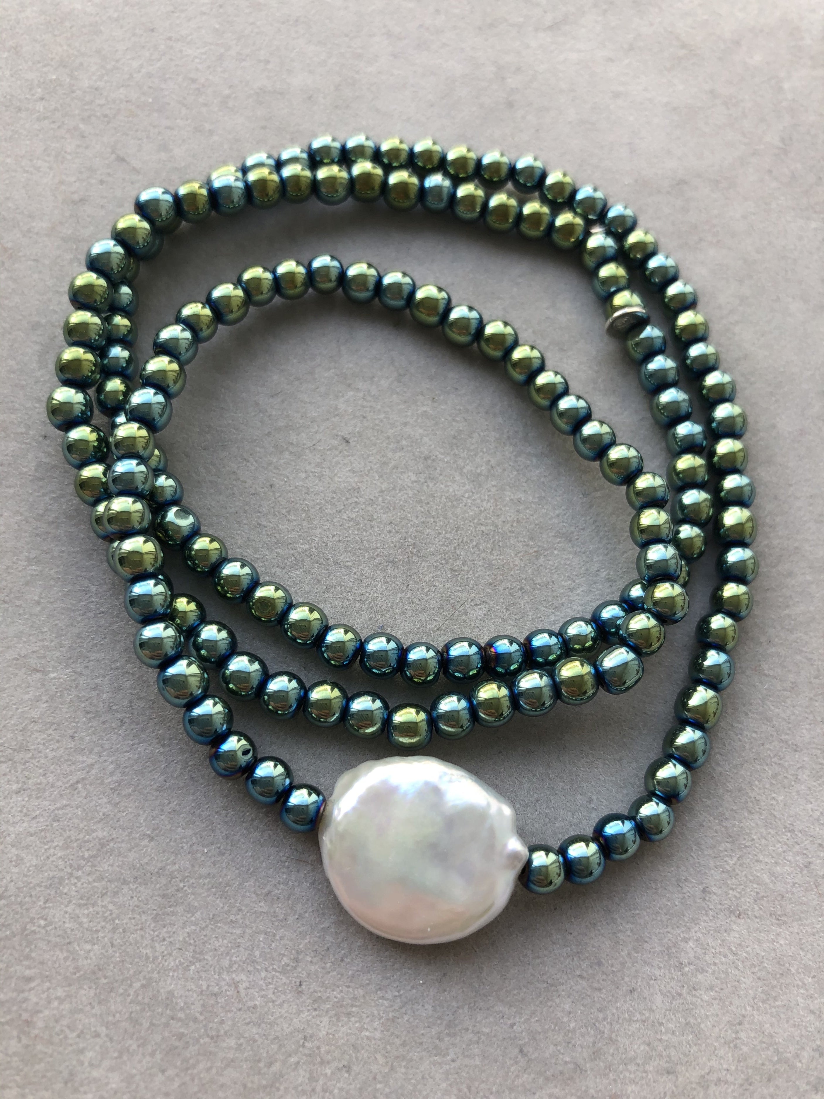 Grüne Hämatitkugeln mit großer, weißer Süßwasserperle