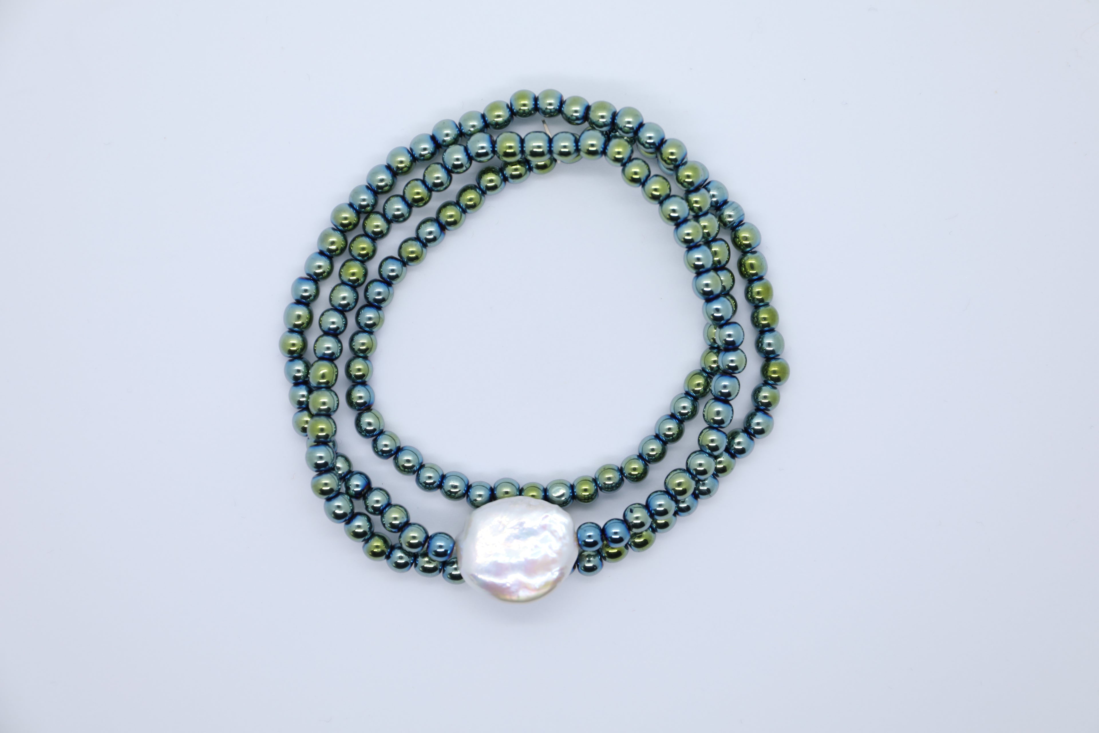 Grüne Hämatitkugeln mit großer, weißer Süßwasserperle