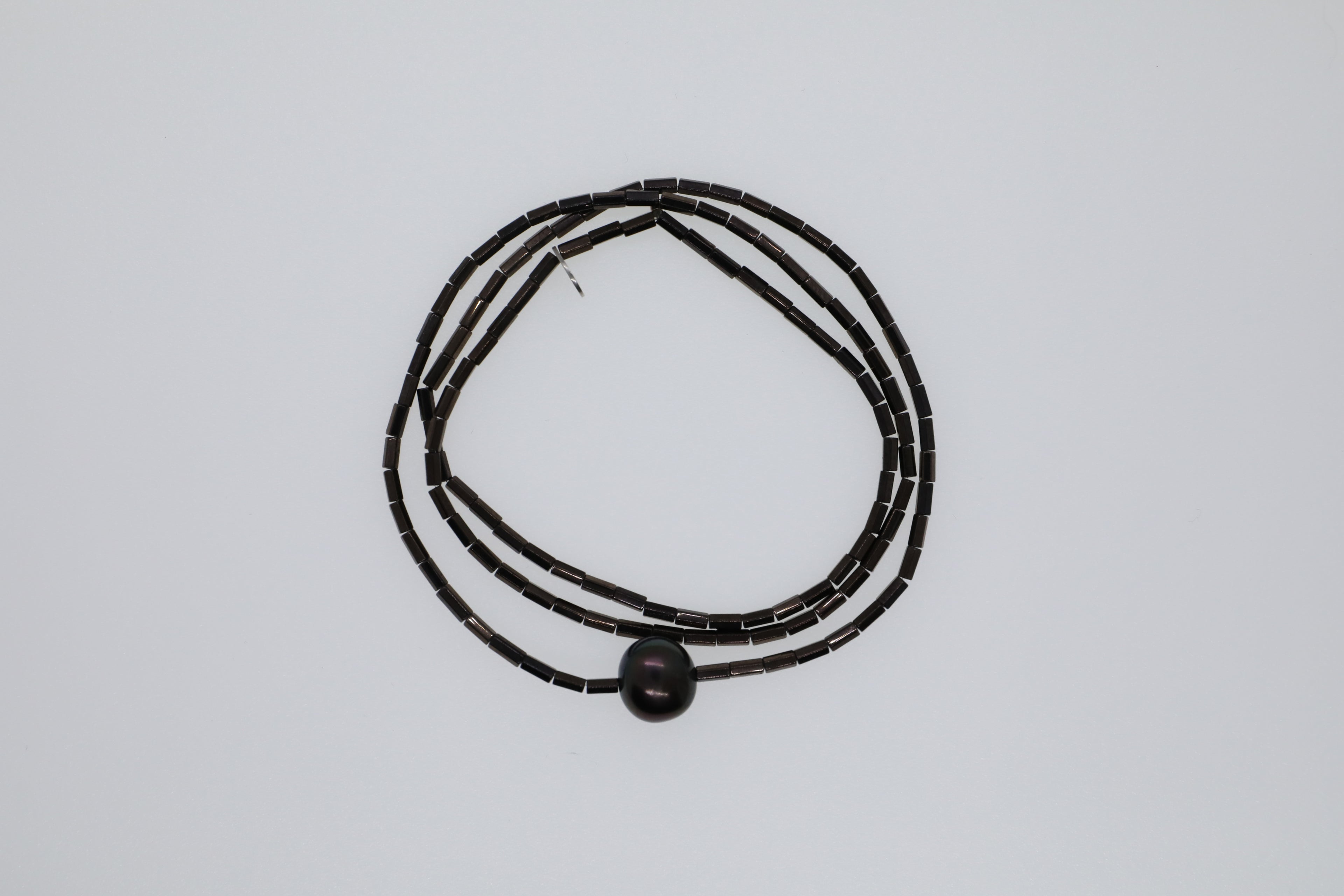 Dunkelbrauner Hämatit und eine braune Süßwasserperle