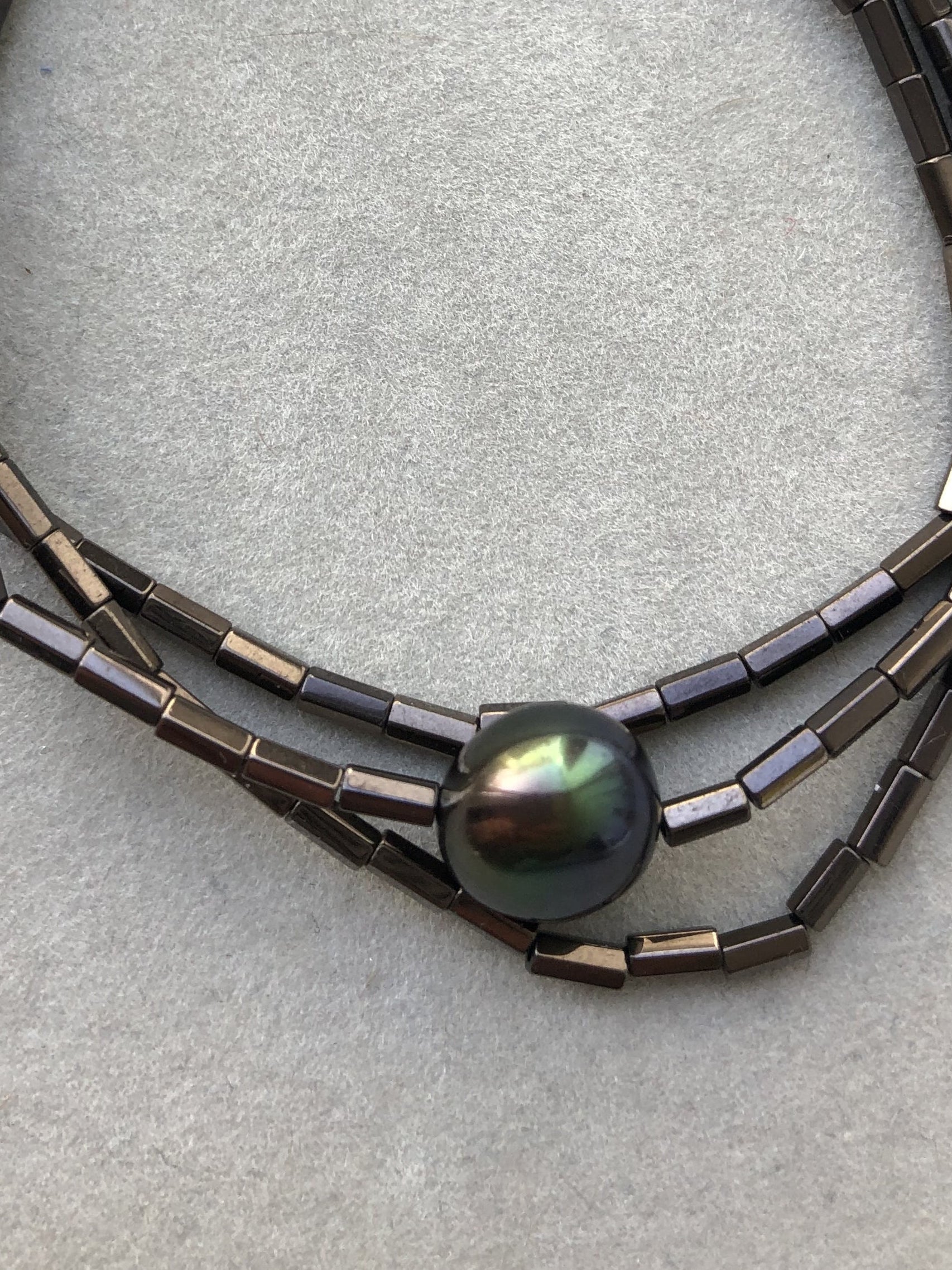 Dunkelbrauner Hämatit und eine braune Süßwasserperle