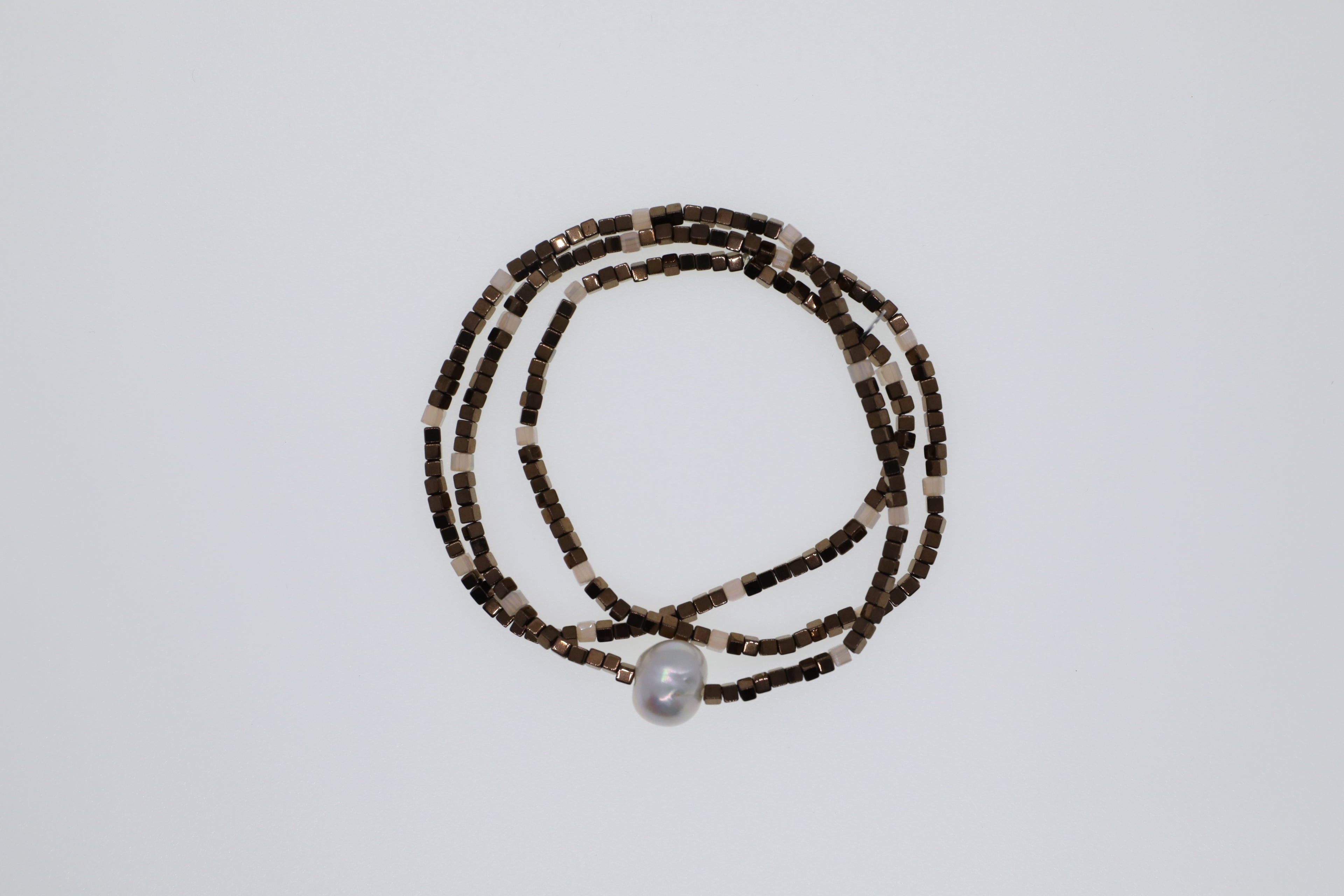 Broncefarbene Hämatite, weiße Glasperlen und eine weiße Süßwasserperle