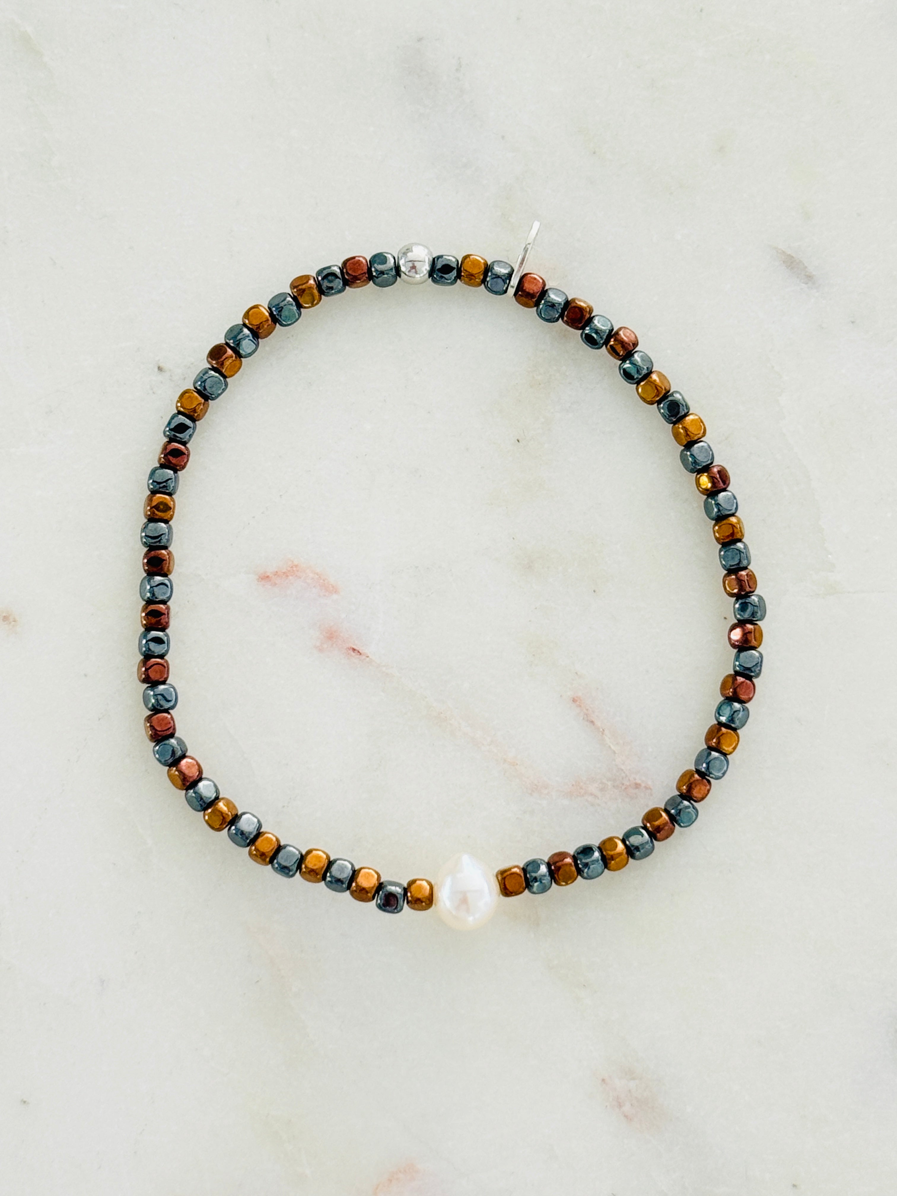 Braune und anthrazitfarbene Hämatite mit Süßwasserperle