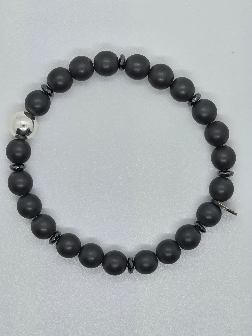 Anthrazitfarbene Hämatitkugeln und glänzende Silberkugel