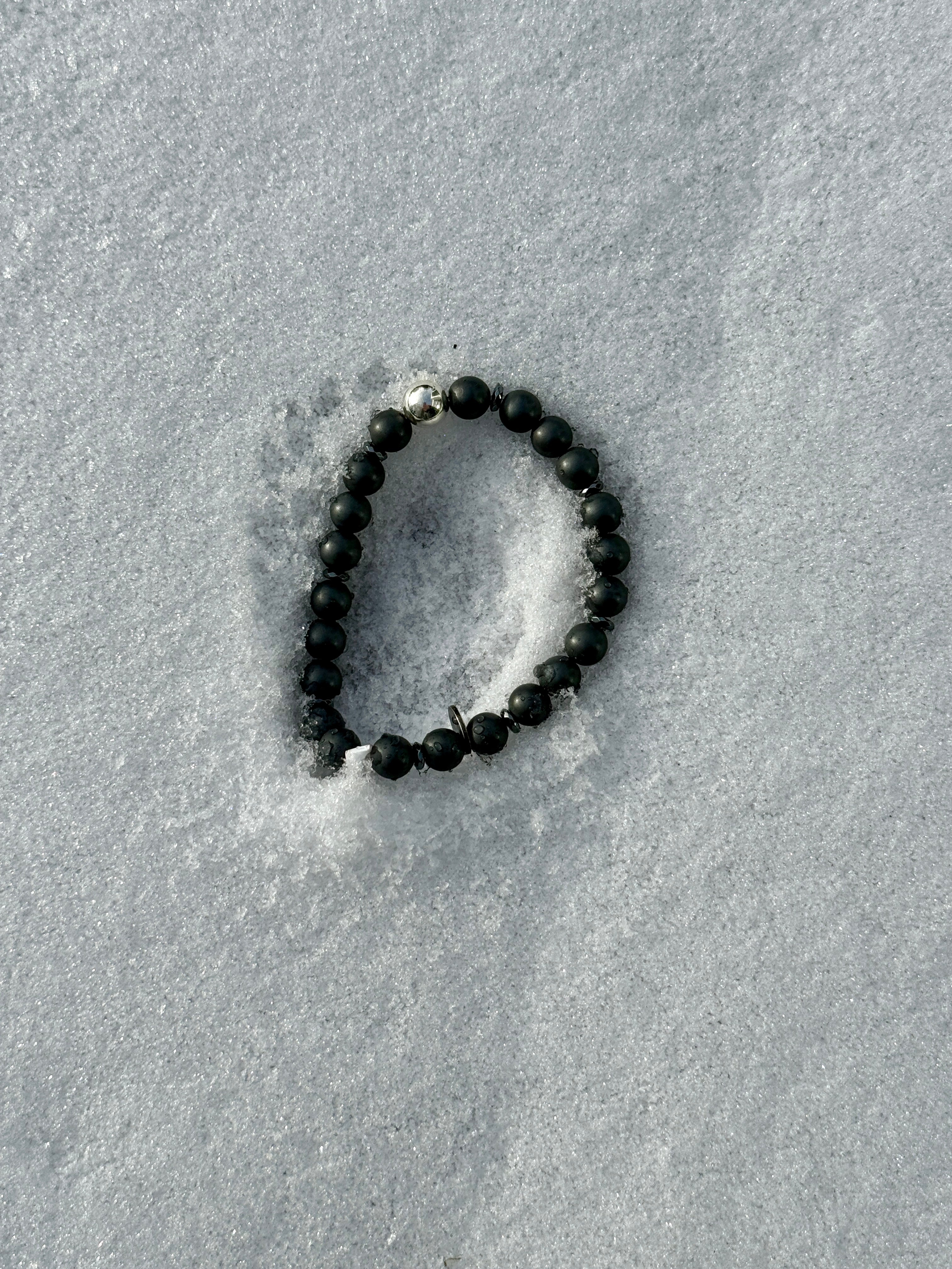 Anthrazitfarbene Hämatitkugeln und glänzende Silberkugel