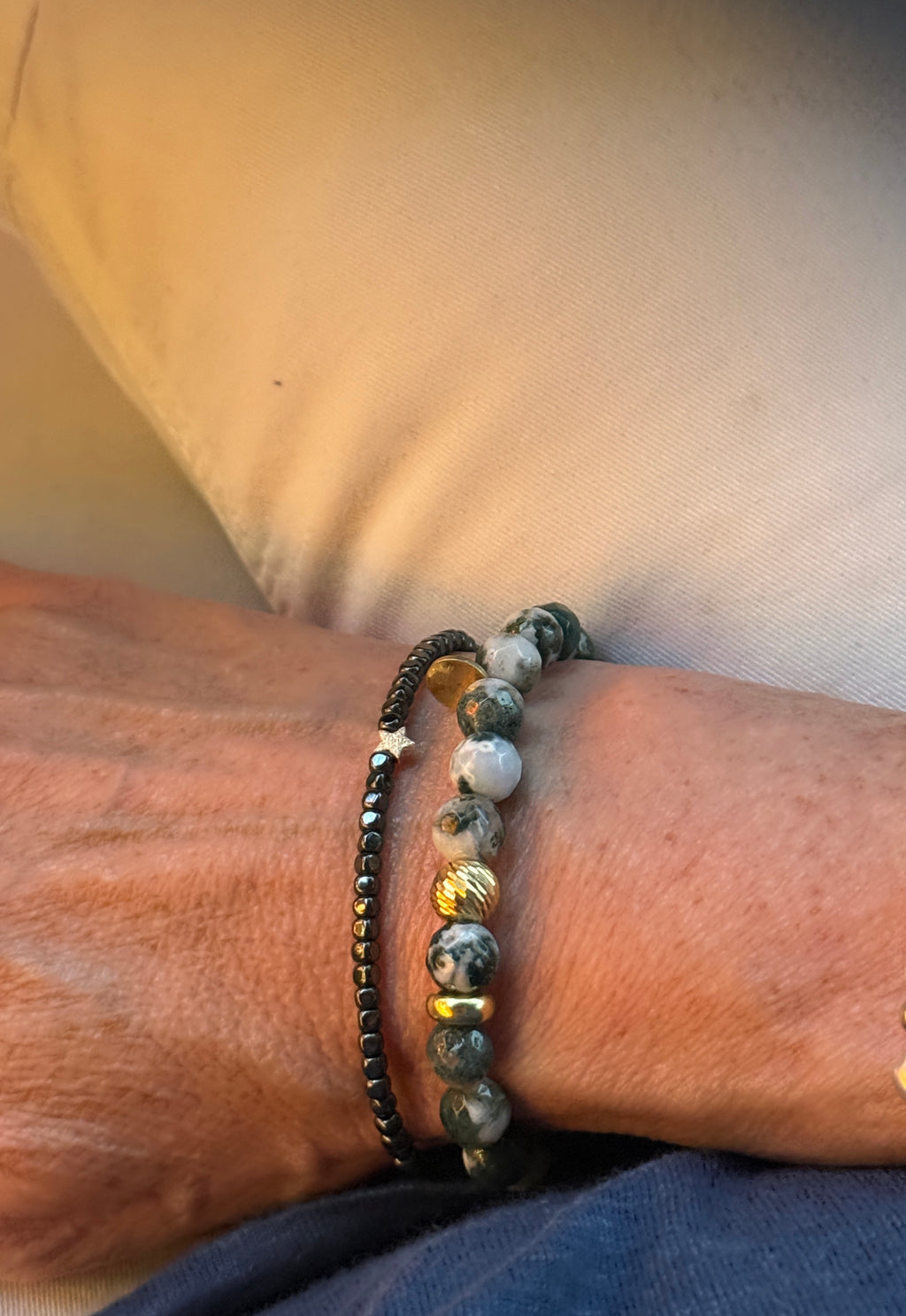 Armband aus anthrazitfarbenen Hämatitwürfeln und einem vergoldeten Stern aus Silber. Dazu eine vergoldete Silberkugel