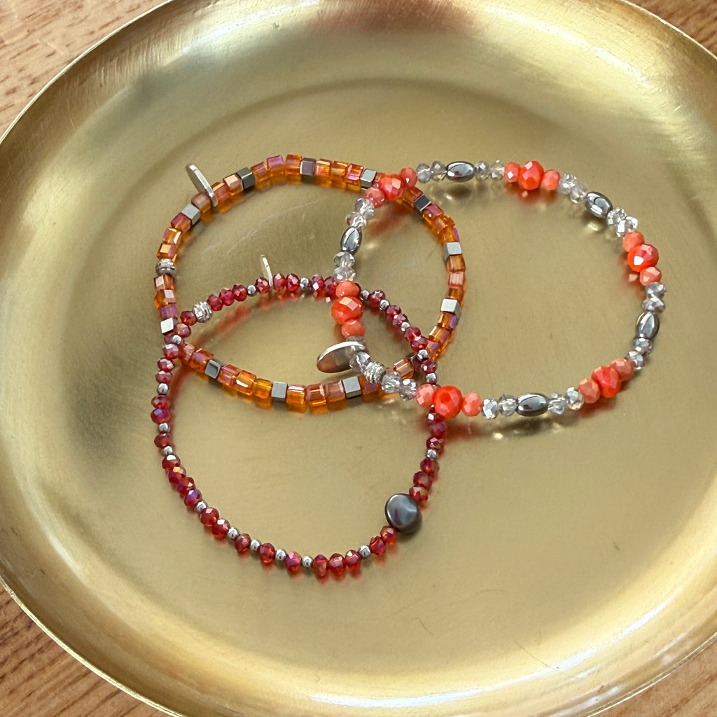Orange Glasperlen mit silberfarbenen Hämatitwürfeln